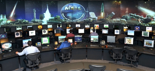 Image of large operation room with lots of computers and people working.
