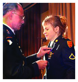 An Army general pins a medal on the uniform of Jessica Lynch during a formal ceremony.