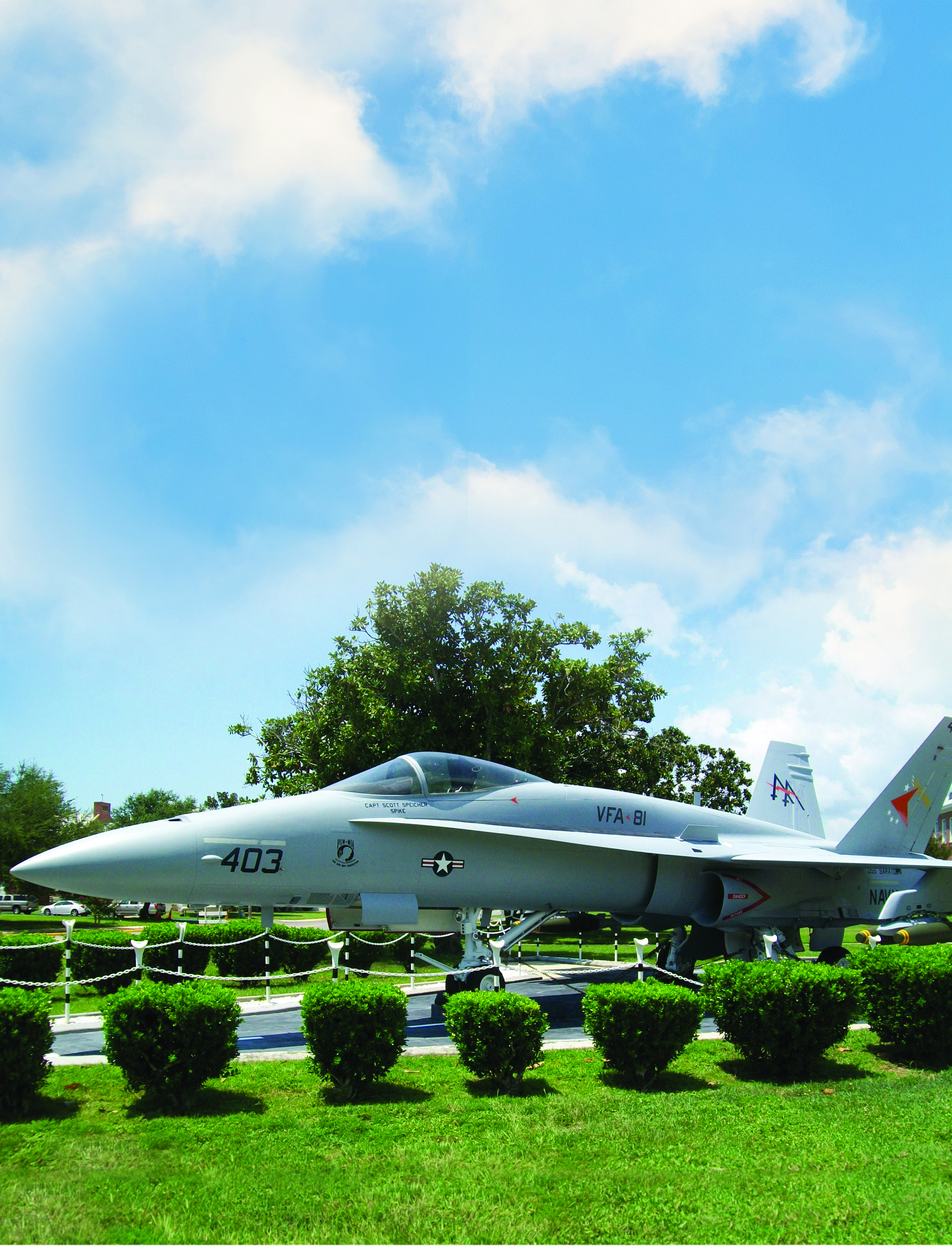 An F/A-18 Hornet fighter jet, tail number 403, on static display at NAS Pensacola, dedicated to Captain Scott Spike Speicher.