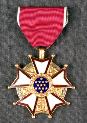 The Meritorious Service Medal, featuring a white and red enamel five-pointed star with a blue center containing 13 white stars, suspended from a red ribbon.