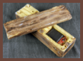 A concealment device disguised as a small log is shown open, revealing a hollowed-out compartment designed to hold a small electronic device.