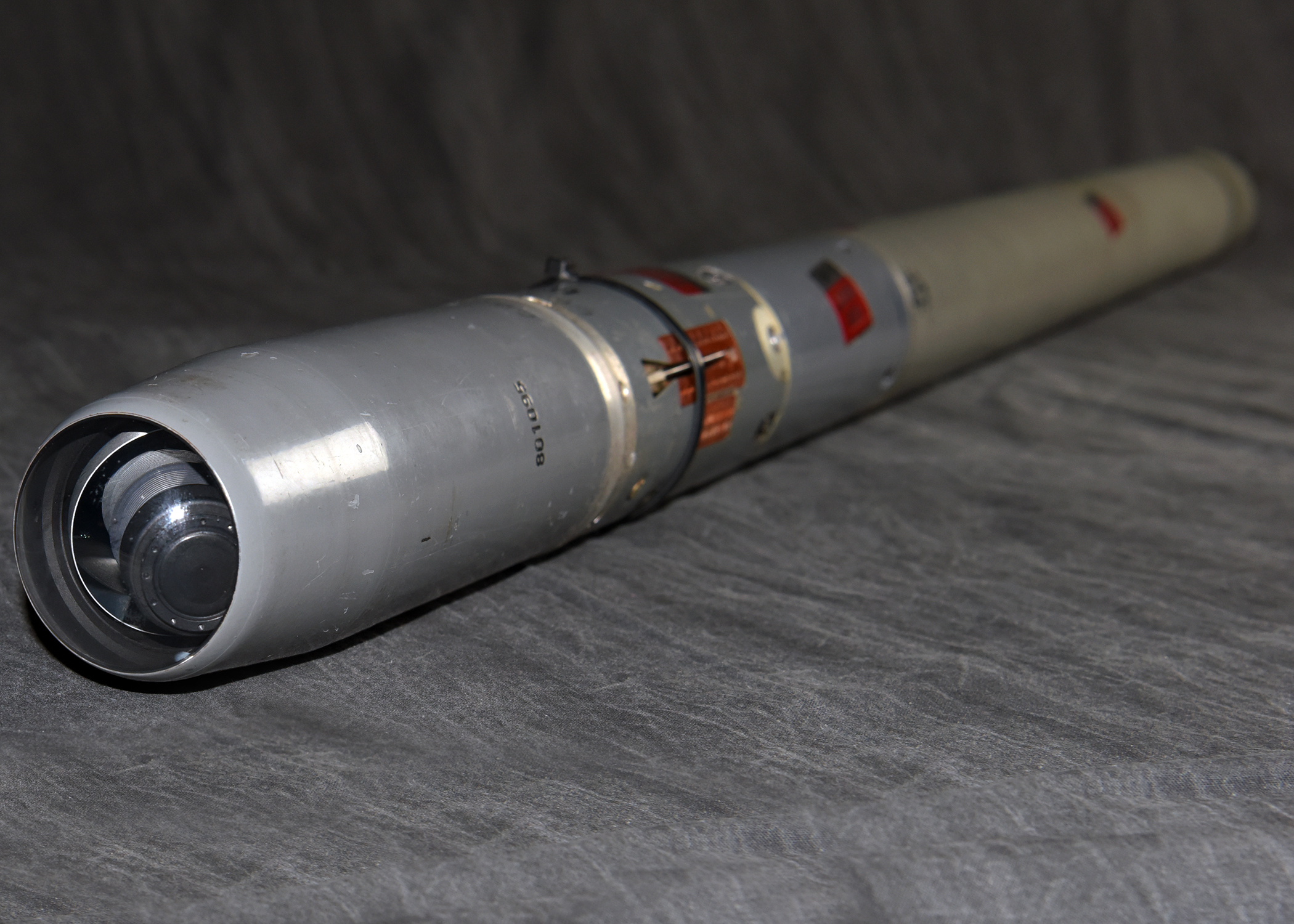 A close-up view of a gray missile's seeker head, which is the guidance system at the tip.