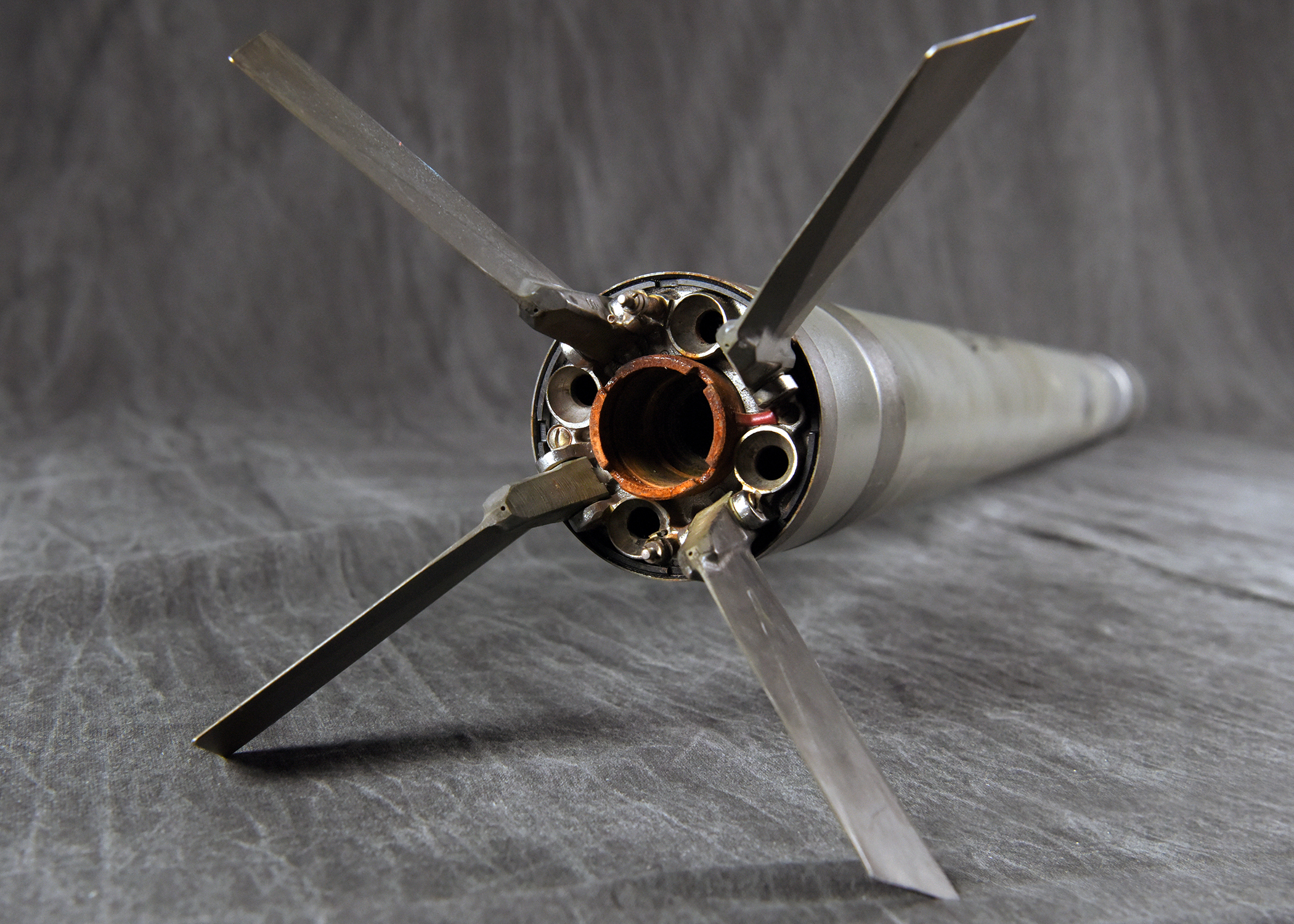 The tail end of a missile, showing its four fins deployed around the exhaust nozzle.