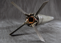 The tail end of a missile, showing its four fins deployed around the exhaust nozzle.