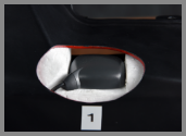 A close-up of a concealment device, marked as 1, hidden within a car bumper, which appears to house a small camera or sensor.