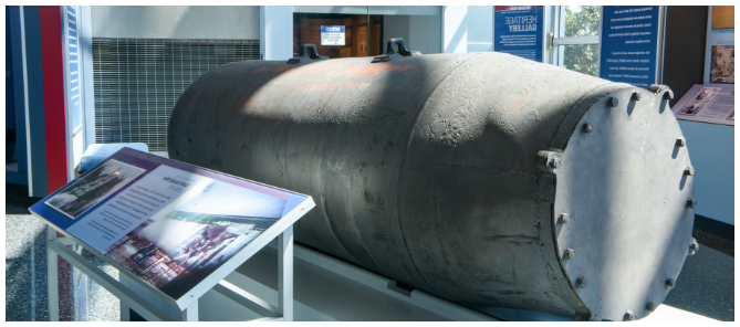 Soviet Acoustic Mine is displayed in a museum next to an informational placard.