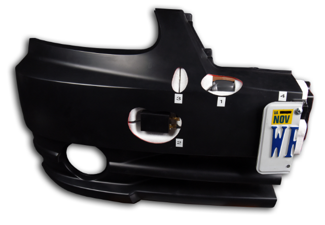 A black car bumper modified with hidden compartments for surveillance. Numbered markers indicate four separate concealments, including one behind a license plate.