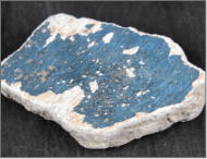 Image of a dark blue painted heavily damaged tile.