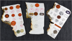Image of 3 strips of damaged or burned paper with stamps on them.